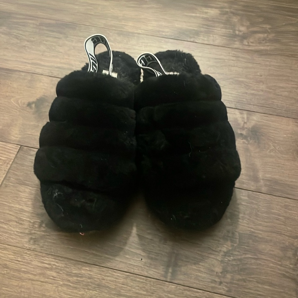 Black fluffy Ugg slides.